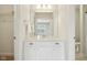 Bathroom vanity with storage cabinets, a sink, and a large mirror; closet and toilet room in view at 13974 Nina Dr, Carmel, IN 46074