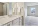 Bright bathroom featuring a stylish vanity with white cabinets and a mirror, with a bedroom doorway in view at 13974 Nina Dr, Carmel, IN 46074