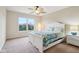 Bright bedroom featuring a white bed frame, fan, and large window overlooking a wooded area at 13974 Nina Dr, Carmel, IN 46074