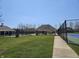 A community tennis court featuring a shelter, fence, and sidewalk surrounded by lush grass at 13974 Nina Dr, Carmel, IN 46074