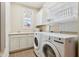 Bright laundry room includes new washer and dryer, storage cabinets and sink at 13974 Nina Dr, Carmel, IN 46074