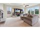 Bright living room featuring a stone fireplace, large windows, and a mirrored entertainment center at 13974 Nina Dr, Carmel, IN 46074