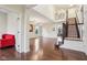 Open-concept living room with hardwood floors, elegant chandeliers, and staircase with dark wood banister at 13974 Nina Dr, Carmel, IN 46074