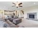 Open-concept living room boasts a stone fireplace, ceiling fan, and seamless access to the kitchen at 13974 Nina Dr, Carmel, IN 46074