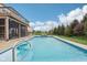 Backyard swimming pool with lighting, fountain features, lounge seating and an expansive grassy area at 13974 Nina Dr, Carmel, IN 46074