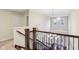 Elegant staircase with wooden banister, iron spindles, and an ornate chandelier at 13974 Nina Dr, Carmel, IN 46074