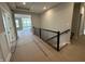 View of hallway with metal railing leading to a living room with large windows at 141 Creststone Blvd, Westfield, IN 46074