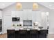 Bright kitchen boasts white cabinets, a center island with seating, and stylish woven pendant lights at 141 Creststone Blvd, Westfield, IN 46074