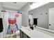 Bright bathroom with a modern vanity, large mirror, and a cute cat-themed shower curtain at 146 Handley St, Indianapolis, IN 46222