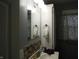 Compact bathroom featuring a sink, mirror, and mosaic tile backsplash at 150 E Carlisle St, Mooresville, IN 46158