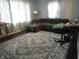 Spacious living room featuring a comfortable gray sectional sofa and a decorative area rug at 150 E Carlisle St, Mooresville, IN 46158