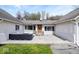 Inviting covered front patio features an outdoor seating area, beautiful front door, and manicured lawn at 1520 E 87Th St, Indianapolis, IN 46240
