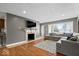 Comfortable living room with a large sectional, hardwood floors, a fireplace, and ample natural light at 1520 E 87Th St, Indianapolis, IN 46240