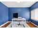 Bright home office with natural light, blue accent wall, white desk, and area rug at 1520 E 87Th St, Indianapolis, IN 46240