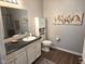 Neutral bathroom featuring granite vanity, a mirrored wall, and a toilet with storage cabinet at 1615 Capra Ct, Beech Grove, IN 46107