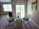 Dining area showcasing a glass table, four chairs, and a sliding glass door at 1615 Capra Ct, Beech Grove, IN 46107