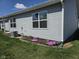 Side view of a house with vinyl siding, a manicured lawn, and a small flower garden at 1615 Capra Ct, Beech Grove, IN 46107