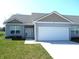 Charming single-story home featuring a two-car garage, manicured lawn, and welcoming front entrance at 1615 Capra Ct, Beech Grove, IN 46107