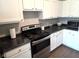 Modern kitchen featuring sleek black appliances, countertops, and white cabinetry at 1615 Capra Ct, Beech Grove, IN 46107