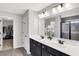 Bright bathroom featuring a double sink vanity, modern lighting, and a view into the tiled shower at 16491 Wheatley Ct, Fishers, IN 46040