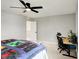Bedroom featuring a black ceiling fan, desk with chair, and view into the hallway at 16491 Wheatley Ct, Fishers, IN 46040