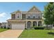 Charming two-story home with a stone facade, attached garage, and well-manicured lawn at 16491 Wheatley Ct, Fishers, IN 46040