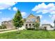 Attractive two-story home with a stone and siding exterior, a manicured lawn, and a charming front porch at 16491 Wheatley Ct, Fishers, IN 46040