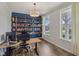 Home office with custom bookshelf, modern desk, two large windows, and ample natural light at 16491 Wheatley Ct, Fishers, IN 46040