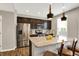 The gourmet kitchen features stainless steel appliances, dark cabinetry, and a large island with seating at 16491 Wheatley Ct, Fishers, IN 46040