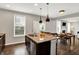 Open-concept kitchen featuring stainless appliances, an island, and a view of the dining and living areas at 16491 Wheatley Ct, Fishers, IN 46040