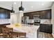 A modern kitchen featuring dark cabinets, stainless steel appliances, and a granite countertop island at 16491 Wheatley Ct, Fishers, IN 46040