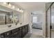 Elegant bathroom with double sink vanity, large mirror, and tiled shower, with easy access to the main bedroom at 16491 Wheatley Ct, Fishers, IN 46040