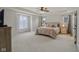 Spacious main bedroom with neutral carpet, tray ceiling, and ample natural light from large windows at 16491 Wheatley Ct, Fishers, IN 46040