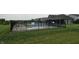 Community pool with clear water, surrounded by a black fence, lounge chairs, and green grass at 16491 Wheatley Ct, Fishers, IN 46040