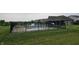 A community pool is surrounded by a black fence, lounge chairs, and grassy areas for resident relaxation at 16491 Wheatley Ct, Fishers, IN 46040