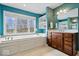 Bright bathroom featuring a soaking tub, double vanity, and a large window offering natural light at 20251 Dayspring Ct, Noblesville, IN 46062