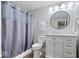 Well-lit bathroom with a modern vanity, round mirror, and shower with stylish gray curtain at 20251 Dayspring Ct, Noblesville, IN 46062