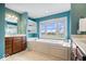 Bright bathroom featuring a soaking tub, double vanity, and a large window offering natural light at 20251 Dayspring Ct, Noblesville, IN 46062
