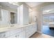 Bright bathroom with double vanity, cabinetry and view into bedroom with blue carpet at 20251 Dayspring Ct, Noblesville, IN 46062