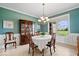 Elegant dining room featuring wainscoting, a chandelier, and a large window offering scenic views at 20251 Dayspring Ct, Noblesville, IN 46062