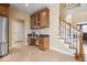 Well-appointed kitchen featuring built-in desk, stairs to second floor, and stainless steel refrigerator at 20251 Dayspring Ct, Noblesville, IN 46062