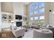Bright living room with soaring ceilings, fireplace, built-in shelving, and oversized windows with backyard view at 20251 Dayspring Ct, Noblesville, IN 46062