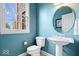 Cozy powder room with pedestal sink, a window, and toilet at 20251 Dayspring Ct, Noblesville, IN 46062