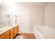 Bathroom featuring a double vanity, large mirror, and separate bathtub and shower at 2416 Meadow Bend Dr, Columbus, IN 47201
