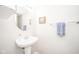 A minimalist powder room features a pedestal sink, round mirror and fresh decor at 2416 Meadow Bend Dr, Columbus, IN 47201
