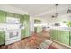 A kitchen boasting green cabinets, white appliances, and seamless flow into the adjacent living area at 2416 Meadow Bend Dr, Columbus, IN 47201