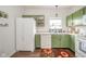 Well-lit kitchen featuring white appliances, green cabinets, and stylish flooring at 2416 Meadow Bend Dr, Columbus, IN 47201