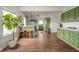 Open-concept kitchen with green cabinetry, a breakfast bar, and modern appliances at 2416 Meadow Bend Dr, Columbus, IN 47201