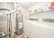An efficient laundry room with modern washer, dryer, water heater and shelving at 2416 Meadow Bend Dr, Columbus, IN 47201