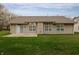 Back exterior view of home, featuring large windows, siding, lawn and concrete patio at 2813 W Long Meadow Ln, Muncie, IN 47304